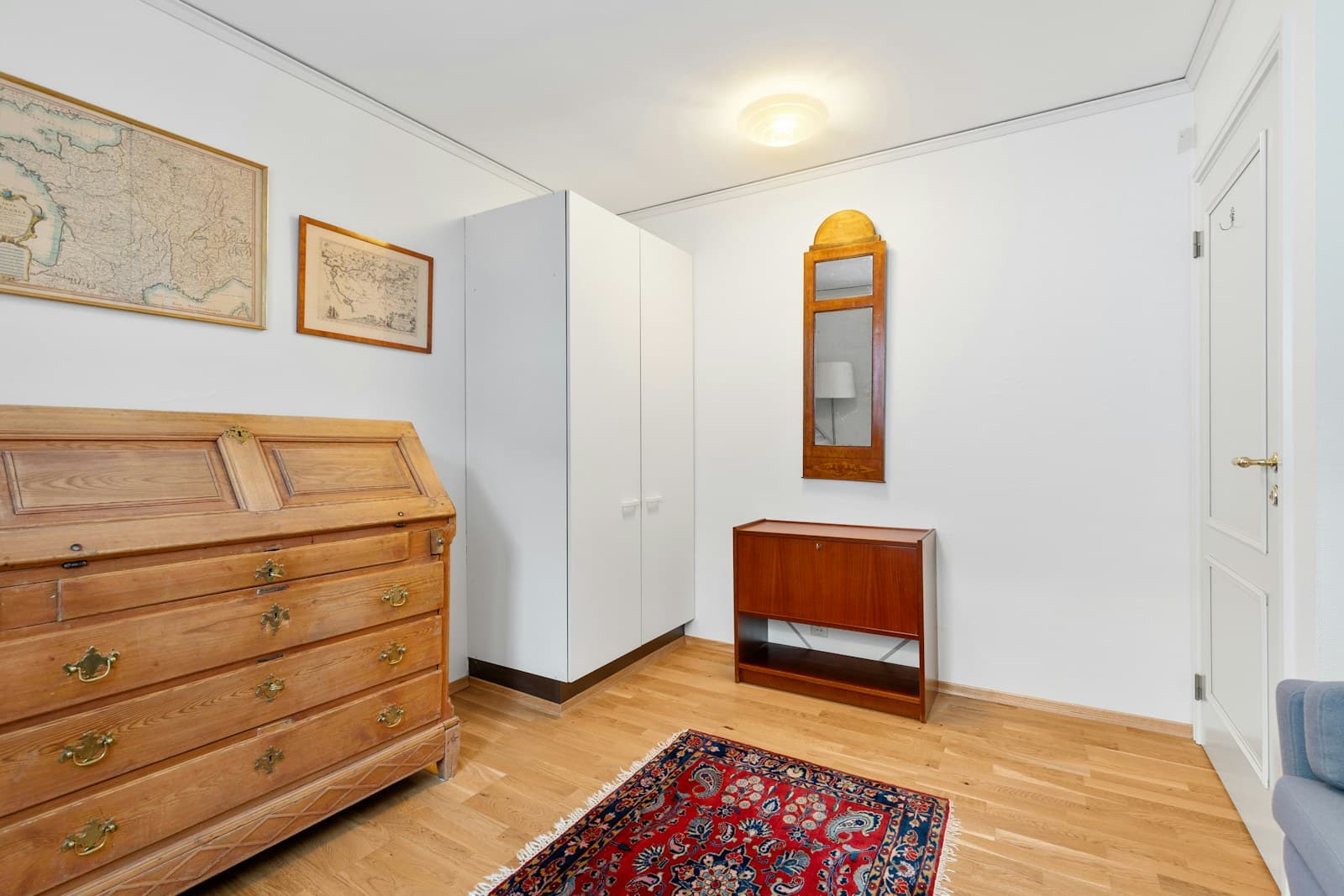 Wood dresser and mirror arranged against a living room wall