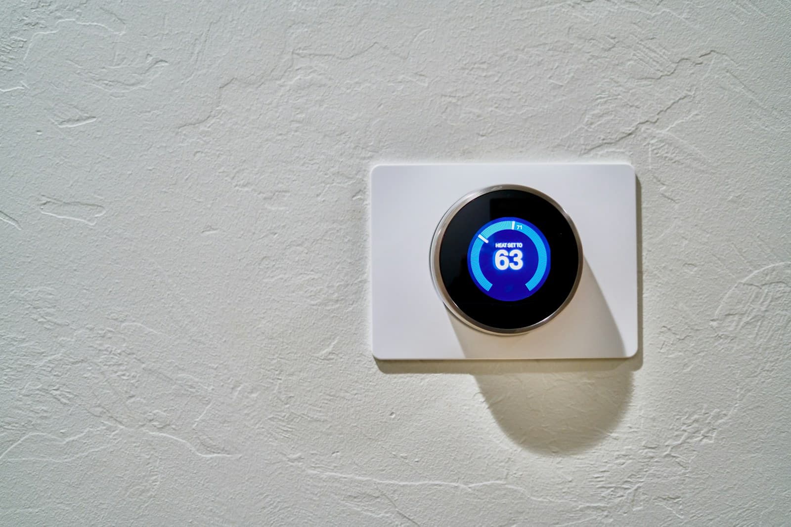Wall-mounted thermostat showing a temperature setting