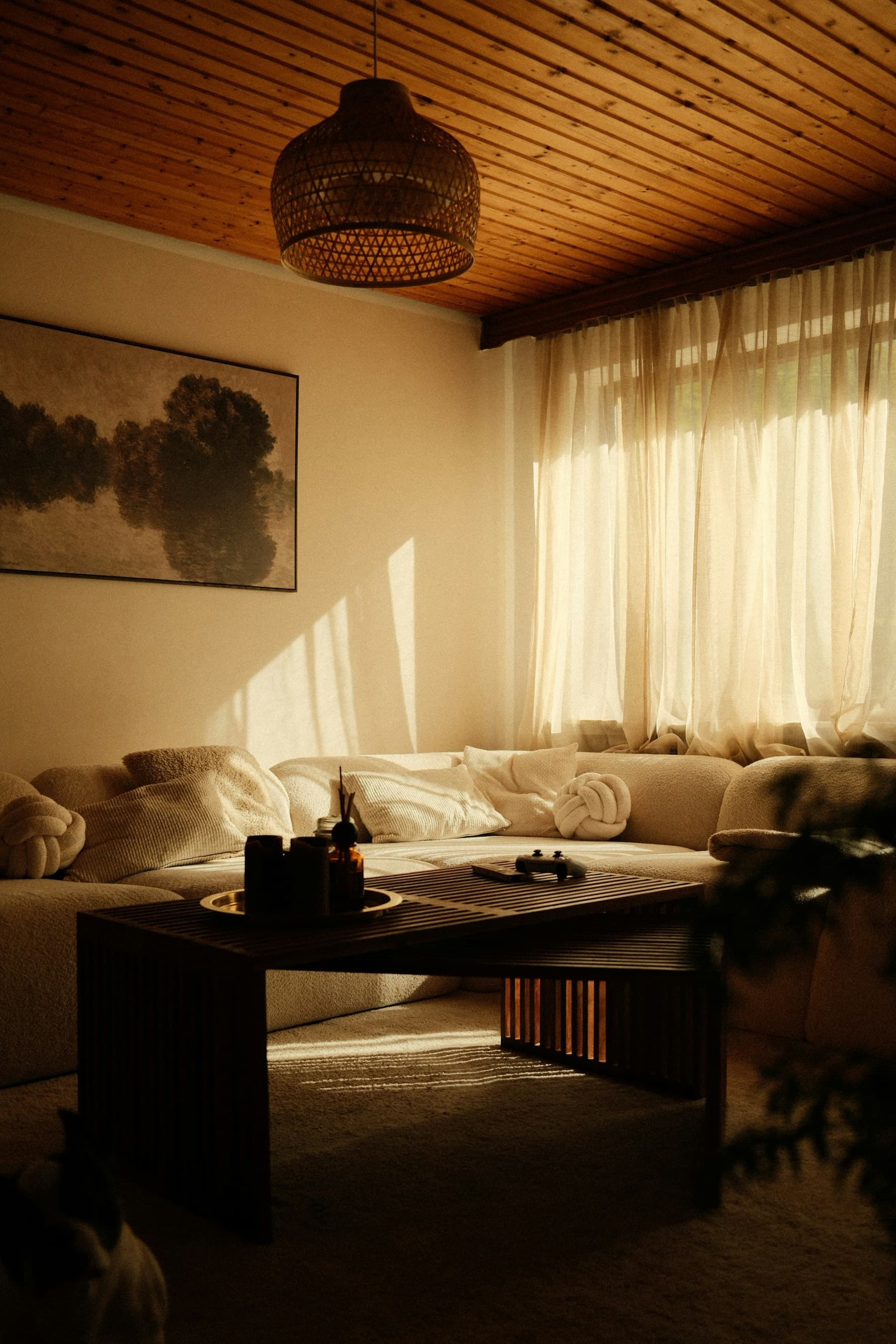 Warm living room with a textured sofa, wood ceiling, and natural window light